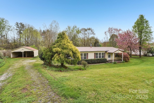 view of front of property with a carport, driveway, a front lawn, and metal roof