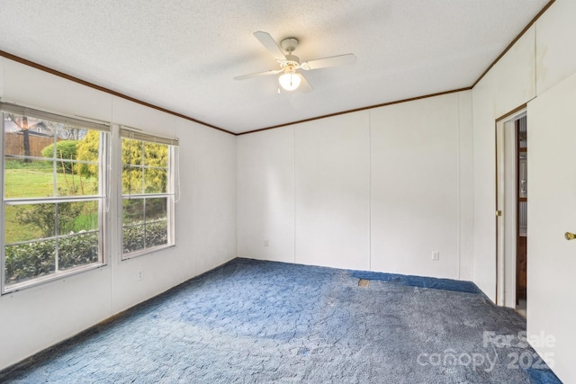carpeted empty room featuring a textured ceiling, a ceiling fan, and ornamental molding
