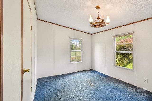 carpeted empty room with a chandelier, ornamental molding, and a wealth of natural light