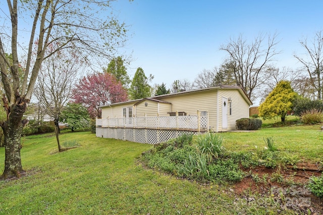 rear view of property featuring a yard and a wooden deck