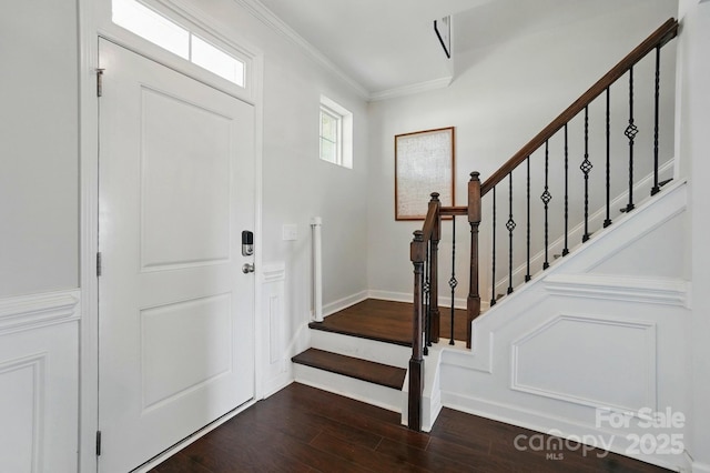 foyer featuring baseboards, ornamental molding, stairs, and dark wood-type flooring