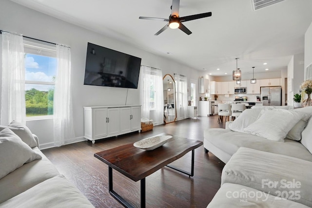 living area featuring recessed lighting, ceiling fan, a wealth of natural light, and dark wood finished floors