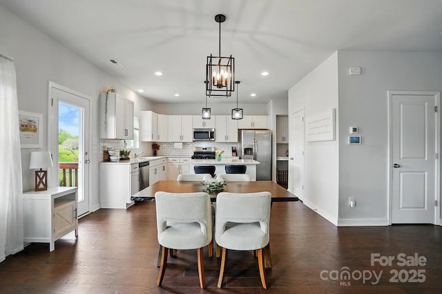 dining space featuring recessed lighting, a notable chandelier, dark wood-type flooring, visible vents, and baseboards