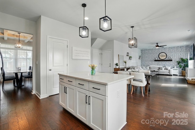 kitchen with dark wood-style floors, white cabinets, a ceiling fan, and hanging light fixtures