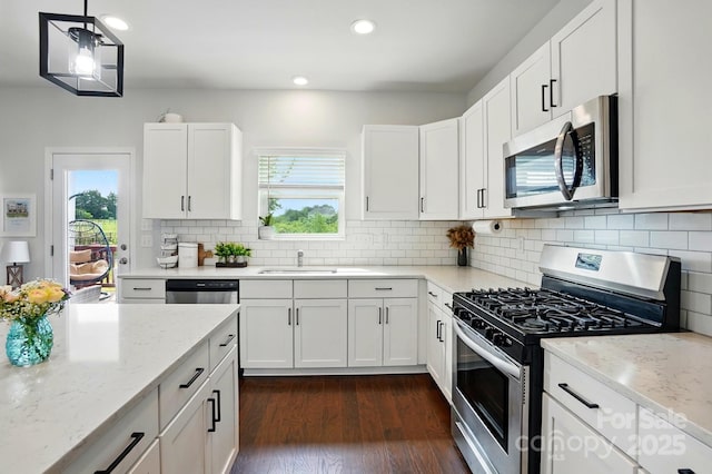 kitchen featuring light stone counters, tasteful backsplash, appliances with stainless steel finishes, and a healthy amount of sunlight