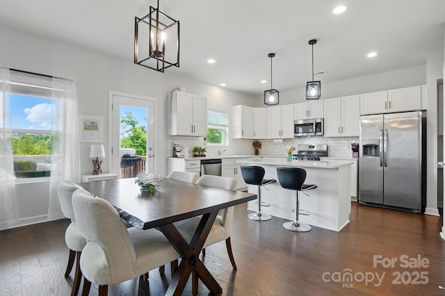 dining space with dark wood-type flooring and recessed lighting