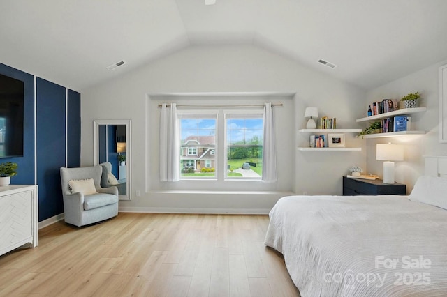 bedroom with vaulted ceiling, visible vents, and light wood-style flooring