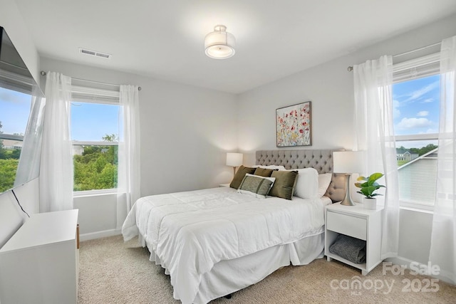 bedroom featuring baseboards, visible vents, and light carpet