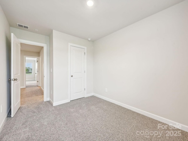 unfurnished bedroom featuring visible vents, baseboards, and carpet flooring