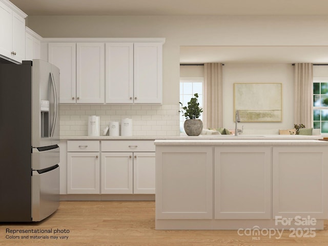 1512 Croydon St, Indian Land, SC 29707 - kitchen with stainless steel fridge, light countertops, light wood-style flooring, white cabinetry, and backsplash