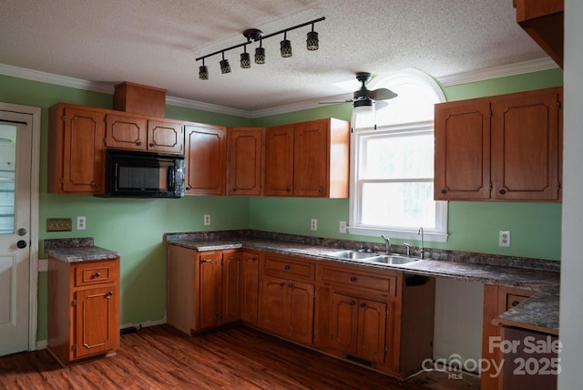 204 Foley Dr, Garner, NC 27529 - kitchen with a sink, a textured ceiling, dark wood-style flooring, brown cabinetry, and black microwave