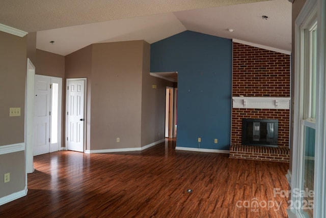 204 Foley Dr, Garner, NC 27529 - unfurnished living room featuring vaulted ceiling, baseboards, a brick fireplace, and wood finished floors