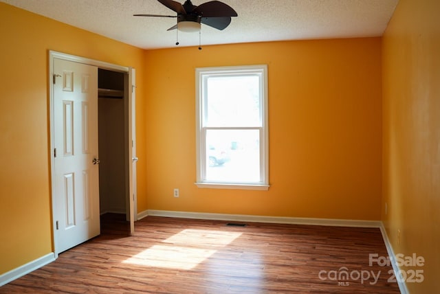 204 Foley Dr, Garner, NC 27529 - unfurnished bedroom with baseboards, wood finished floors, and multiple windows
