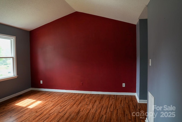 204 Foley Dr, Garner, NC 27529 - spare room with vaulted ceiling, wood finished floors, visible vents, and baseboards