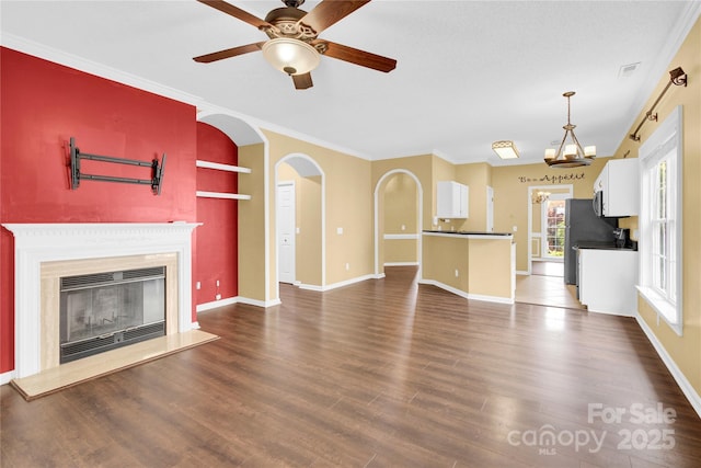 4155 Guilford Ct NW, Concord, NC 28027 - unfurnished living room with dark wood-type flooring, a glass covered fireplace, arched walkways, ceiling fan, and baseboards