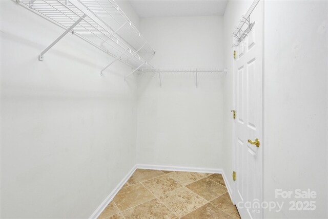 4155 Guilford Ct NW, Concord, NC 28027 - walk in closet featuring light stone finish floors