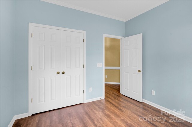 4155 Guilford Ct NW, Concord, NC 28027 - unfurnished bedroom with ornamental molding, a closet, wood finished floors, and baseboards