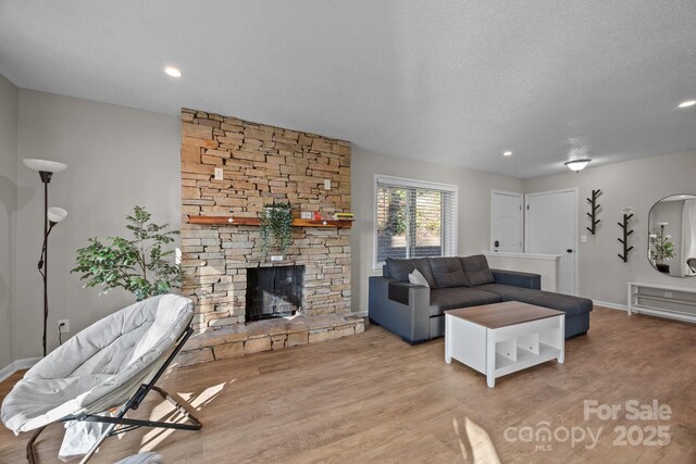 159 Long John Dr, Hendersonville, NC 28791 - living room with a stone fireplace, baseboards, recessed lighting, a textured ceiling, and wood finished floors