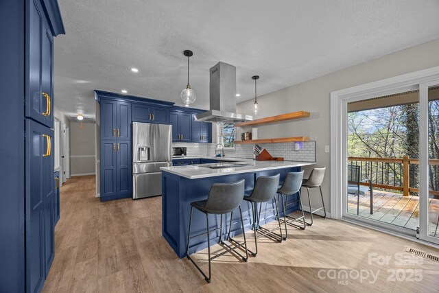 159 Long John Dr, Hendersonville, NC 28791 - kitchen with baseboards, island exhaust hood, stainless steel fridge, a peninsula, and blue cabinetry