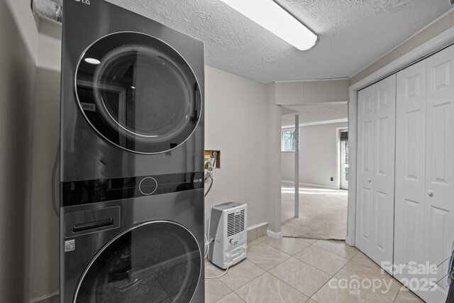 159 Long John Dr, Hendersonville, NC 28791 - clothes washing area with a textured ceiling, stacked washer and clothes dryer, baseboards, and light tile patterned floors