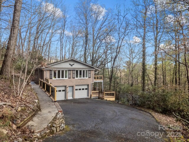 159 Long John Dr, Hendersonville, NC 28791 - view of property exterior featuring a garage, aphalt driveway, and a forest view