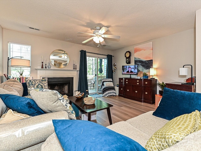 9305 Four Mile Creek Rd, Charlotte, NC 28277 - living room featuring wood finished floors, visible vents, a fireplace, a textured ceiling, and ceiling fan