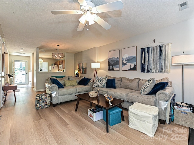 9305 Four Mile Creek Rd, Charlotte, NC 28277 - living area with visible vents, wood finished floors, a textured ceiling, and ceiling fan with notable chandelier