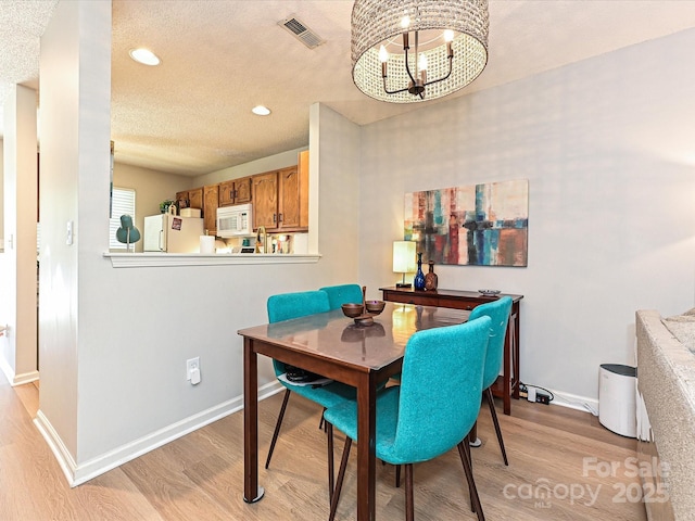 9305 Four Mile Creek Rd, Charlotte, NC 28277 - dining space featuring baseboards, visible vents, light wood-style floors, and a chandelier