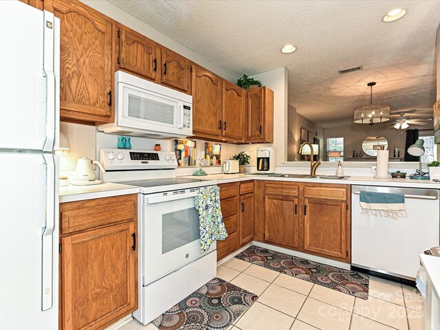 9305 Four Mile Creek Rd, Charlotte, NC 28277 - kitchen with a sink, a textured ceiling, brown cabinetry, white appliances, and light countertops