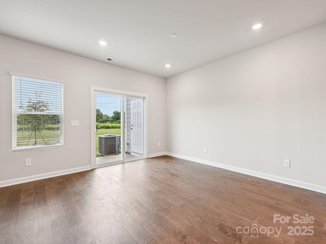 spare room featuring dark wood-style flooring, baseboards, and recessed lighting