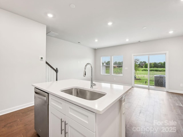 kitchen featuring a sink, dishwasher, dark wood-style floors, light countertops, and recessed lighting