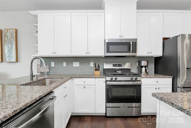 kitchen featuring open shelves, appliances with stainless steel finishes, white cabinetry, and a sink