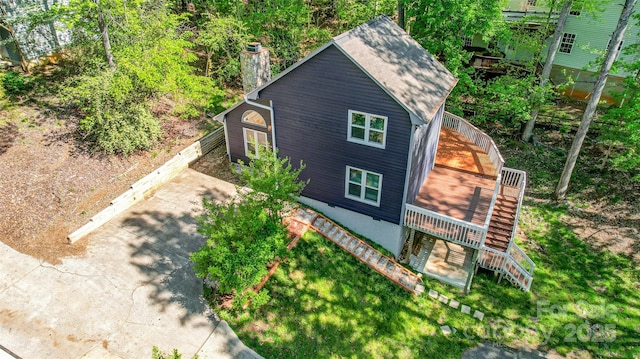 view of side of home featuring a chimney and stairs
