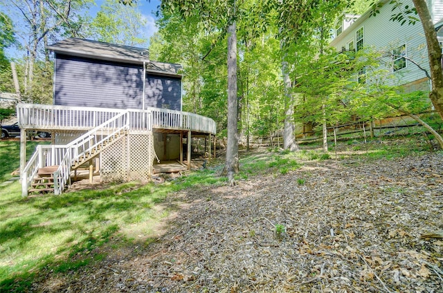 view of yard featuring fence, a deck, and stairs