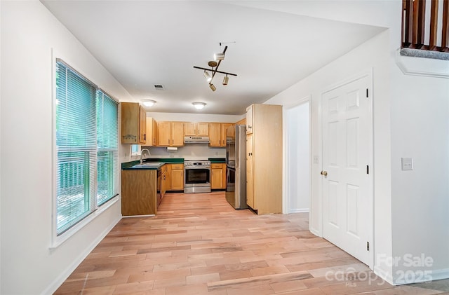kitchen featuring freestanding refrigerator, light wood-style flooring, stainless steel range with electric stovetop, under cabinet range hood, and a sink
