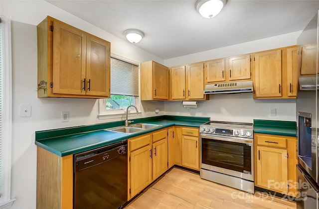 kitchen featuring a sink, light wood-type flooring, dark countertops, under cabinet range hood, and stainless steel appliances