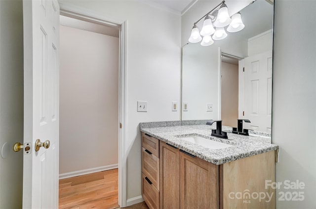 bathroom with wood finished floors, vanity, and baseboards