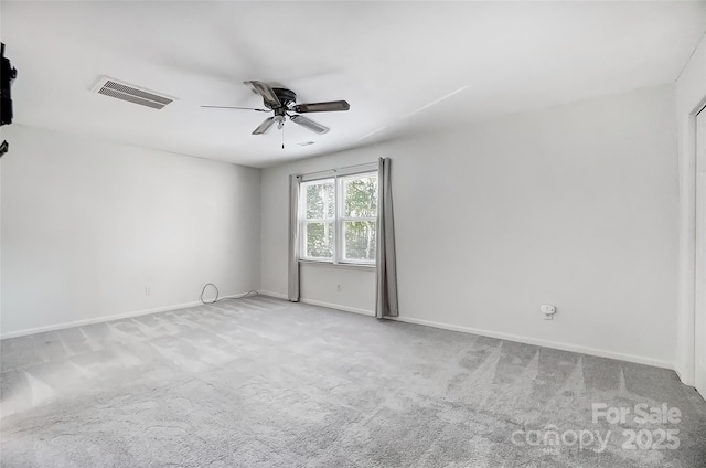 carpeted empty room featuring visible vents, ceiling fan, and baseboards