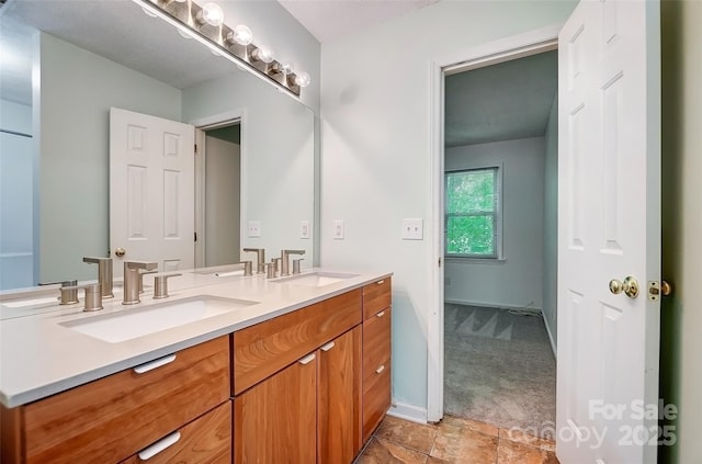full bath featuring double vanity, baseboards, and a sink