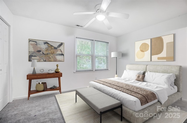 carpeted bedroom featuring visible vents, baseboards, and a ceiling fan