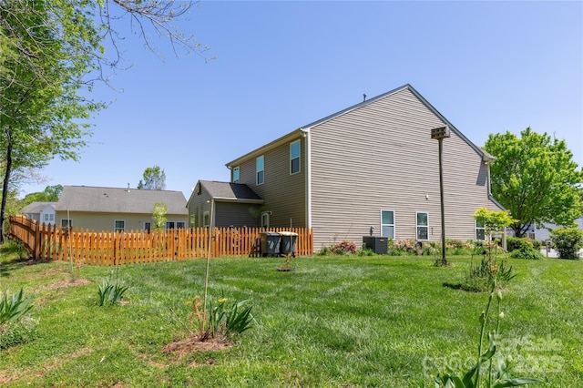 view of side of property featuring fence, a lawn, and central air condition unit