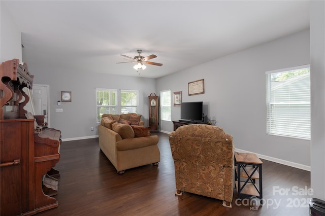 living room with baseboards, dark wood-type flooring, and ceiling fan