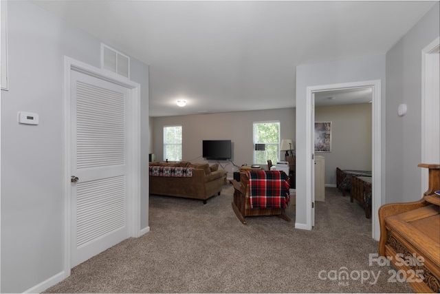 carpeted living room featuring baseboards