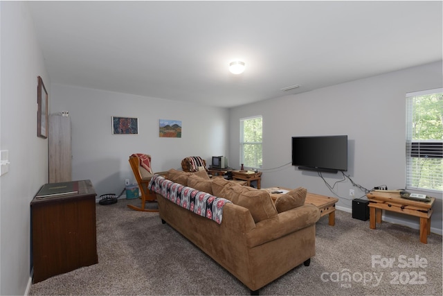 carpeted living area with plenty of natural light and baseboards