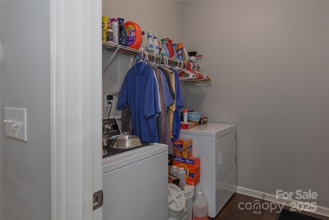 laundry area featuring washing machine and clothes dryer, wood finished floors, laundry area, and baseboards