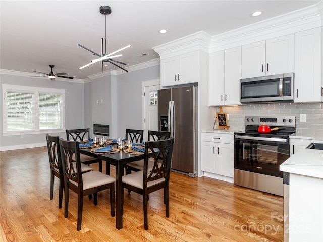 dining room with recessed lighting, baseboards, light wood-type flooring, visible vents, and ornamental molding