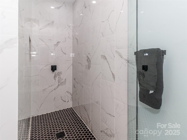 bathroom featuring a marble finish shower