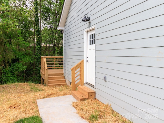 view of exterior entry with a wooden deck