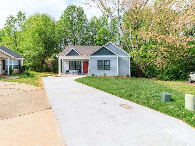 ranch-style home featuring a front yard and concrete driveway