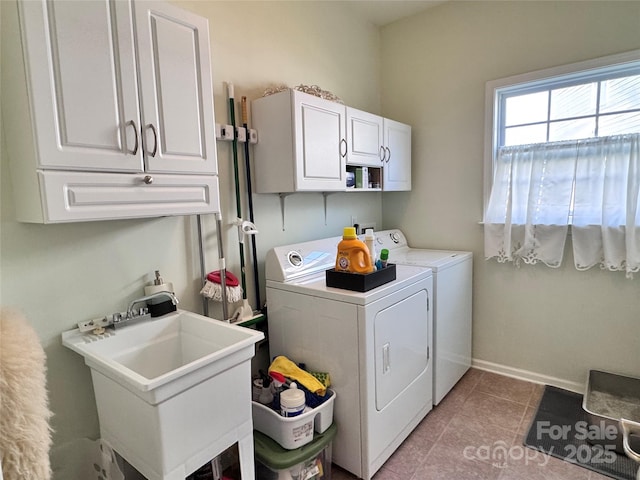 laundry area with washing machine and clothes dryer, a sink, light tile patterned floors, cabinet space, and baseboards